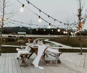 Schön geschmückter Hochzeitstisch mit Lichterkette im Außenbereich auf dem Krewelshof.
